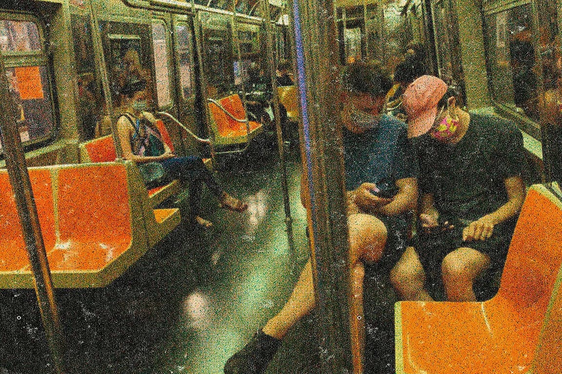 People ride on a train with surgical masks on.